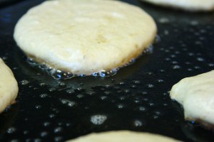 wheat pancakes cooking in butter bubbles