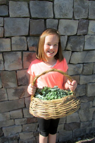 child with a basket of kale