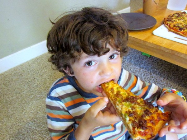 child eating pizza